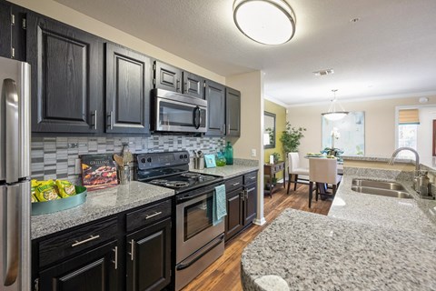 a kitchen with granite counter tops and black cabinets